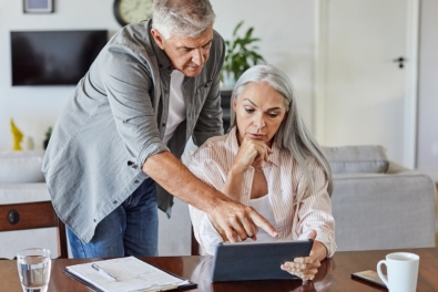 Paar diskutiert über Unterlagen für Immobilienverkauf